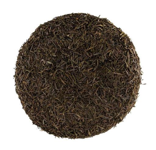 The 7 Brown Flower Center MD037004 is a circular and compact disc of dark dried tea leaves, resembling a sunflower center from above. It has a coarse texture with small leaf fragments and a uniform deep brown color indicating rich fermentation.