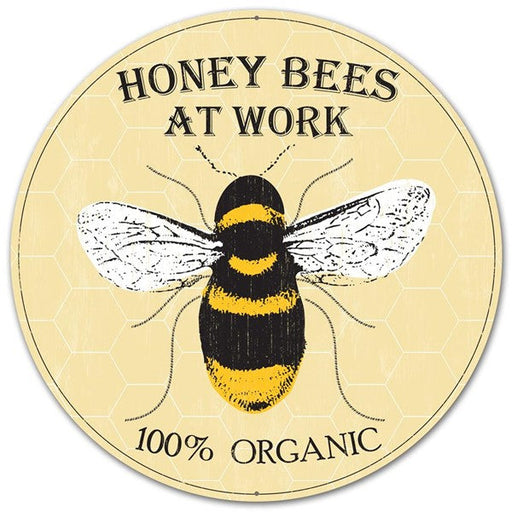 The 12Dia Metal Honey Bee Sign (MD0459) in yellow/black/white features a central bee illustration, honeycomb background, and the words “HONEY BEES AT WORK” above and “100% ORGANIC” below—ideal for highlighting active honey bees.