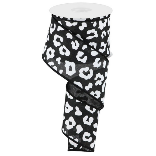 A roll of 2.5 black and white animal print ribbon, known as RGC140402, featuring a striking leopard pattern, is partially wrapped around the spool.