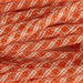 Close-up of the Deco Poly Flex Tubing in Orange White Stripe, featuring a vibrant orange rope with a crisscross pattern reminiscent of festive mesh tubing.