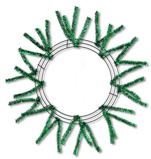 The 24 Pencil Work Wreath Metallic Emerald Green (XX751106) features sparse green artificial pine branches and metallic emerald green mesh on a circular wire base, elegantly set against a white background.